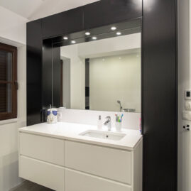 Szafka łazienkową biało-czarna z białym blatem i podwieszaną umywalką