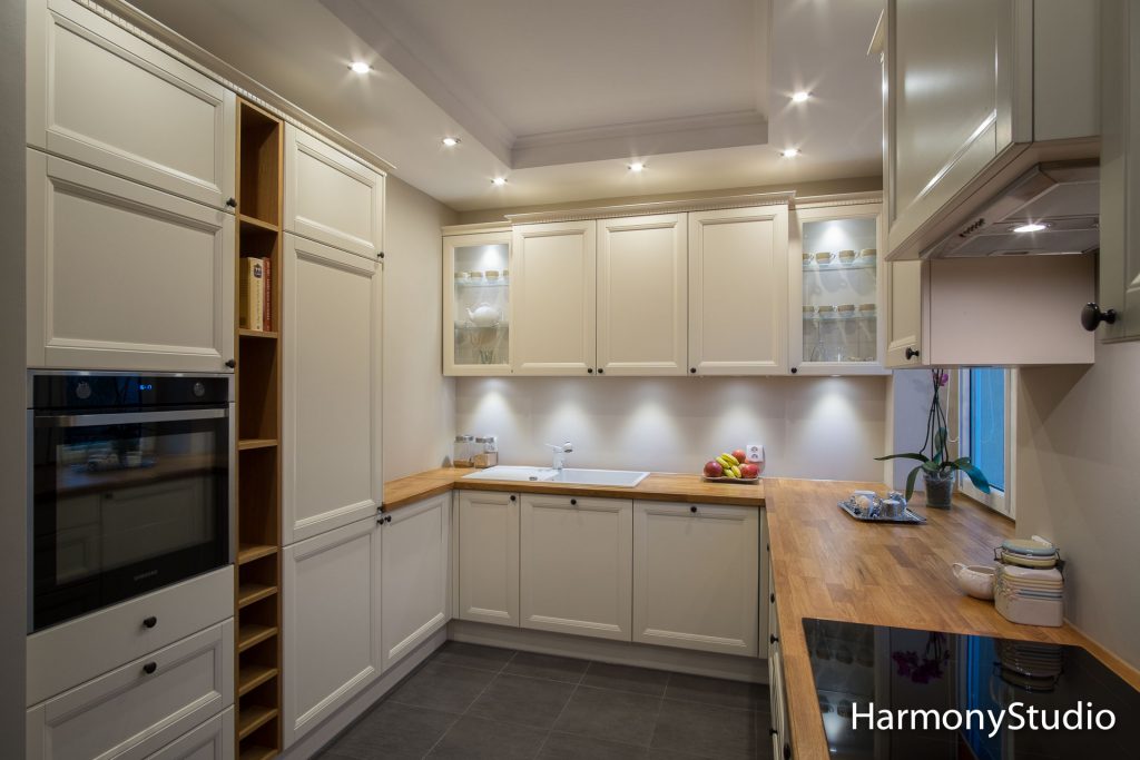 klasyczne meble kuchenne z jasnymi frontami i drewnianym blatem